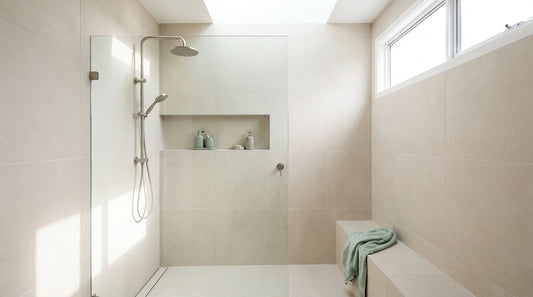 A spotless modern Australian walk-in shower, pale tiles and a clear glass screen, bright natural light, clean grout and 