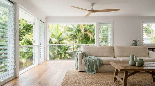 A bright contemporary Queenslander interior with timber floors, louvre windows open to greenery, ceiling fan, airy and f